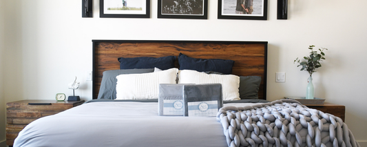 Bedroom with a wooden headboard, Sweet Sheets® double-brushed microfiber sheets in Silver Sprinkles light gray and decorative pillows on a bed.