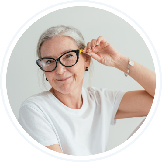 older woman with glasses smirking playfully