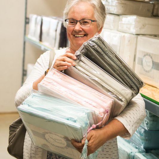Woman holding a stack of Sweet Sheets® in a warehouse setting